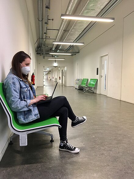 Frau sitzend auf einem Gang