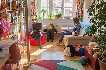 Im Kinderzimmer sitzen Adina Herde und ihre beiden Kinder vor Laptops