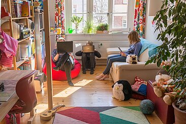 Im Kinderzimmer sitzen Adina Herde und ihre beiden Kinder vor Laptops